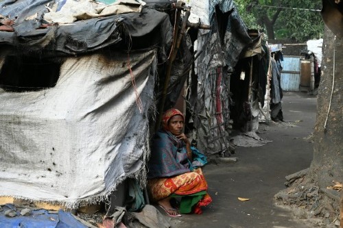 woman sitting outside shack in third world country